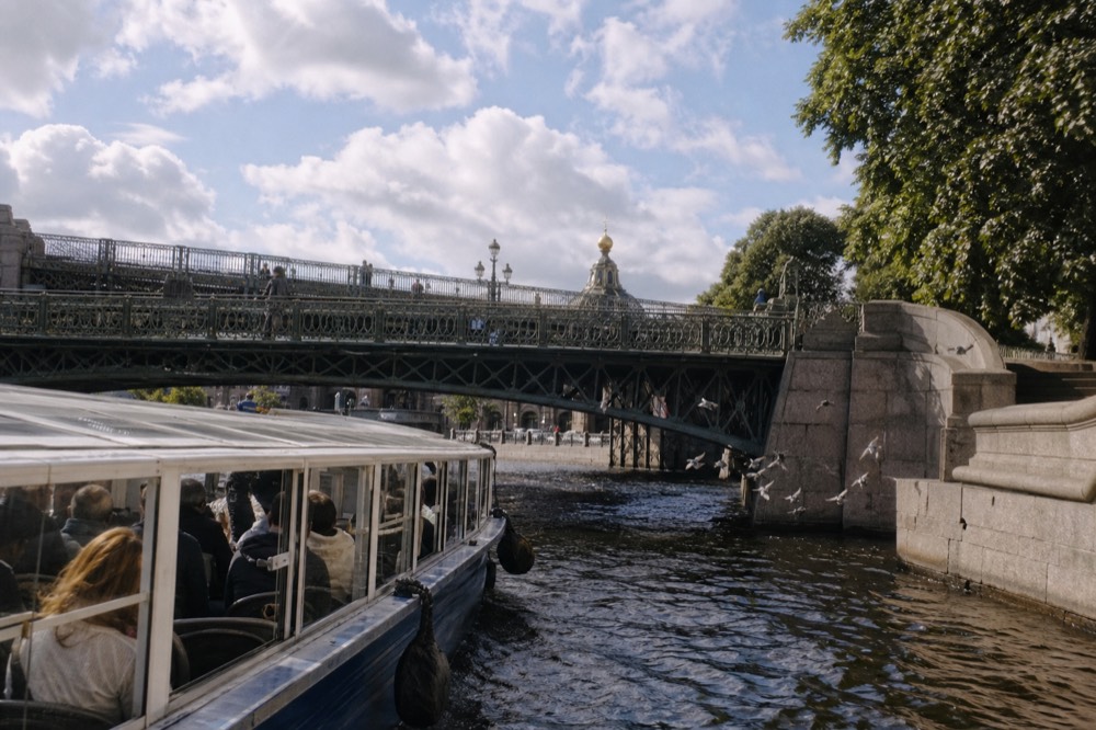 A glass-roofed cruise boat passing ornate Parisian bridges on the Seine, no text, no logos, no people
