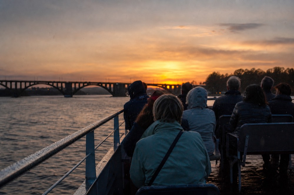 A crowded cruise boat upper deck on the Seine at sunset in Paris, no text, no logos, no people
