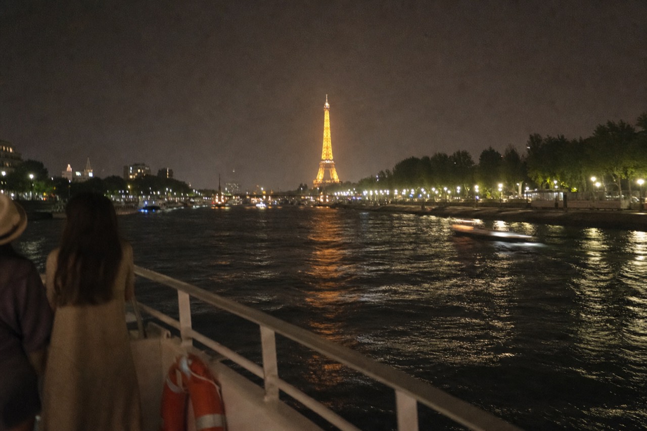 Illuminated Eiffel Tower seen from the Seine at night, no text, no logos, no people