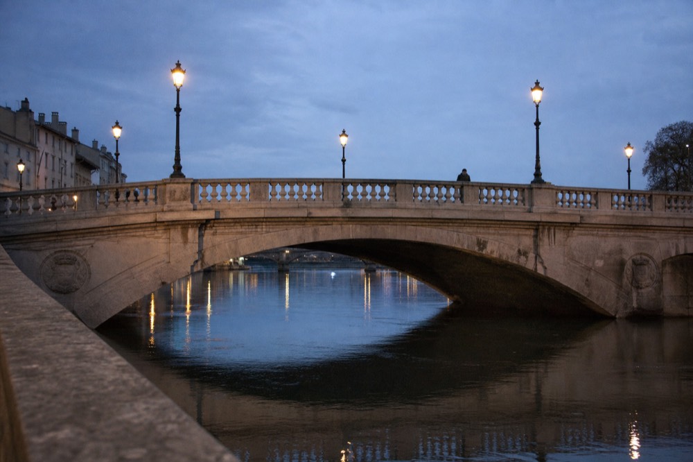 Illuminated Paris bridge reflected in the Seine at night, no text, no logos, no people