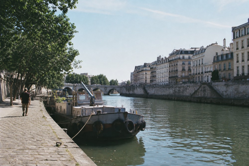 The Seine flowing past stone quays and Parisian buildings on a clear day, no text, no logos, no people
