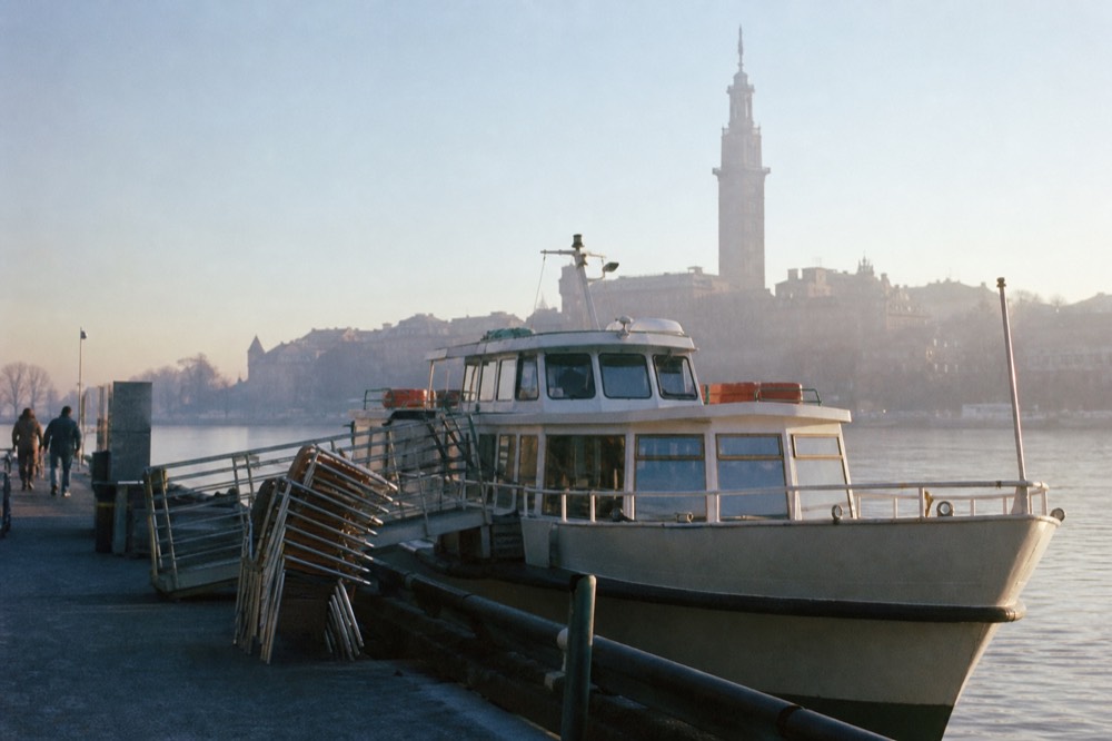 A passenger boat moored at a Seine quay with the Eiffel Tower behind it, no text, no logos, no people