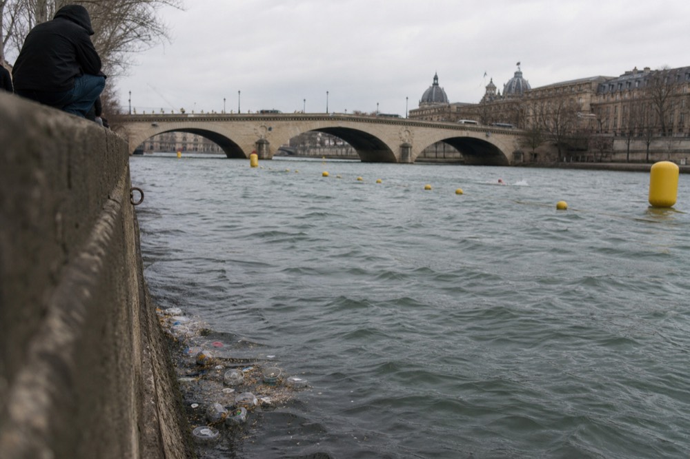 Open-water swimming course markers on the Seine near a Paris bridge, no text, no logos, no people