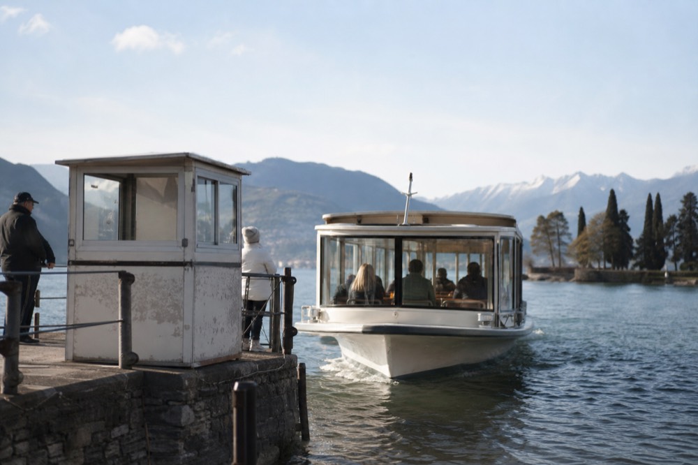 A glass-enclosed Batobus shuttle boat approaching a stop on the Seine, no text, no logos, no people