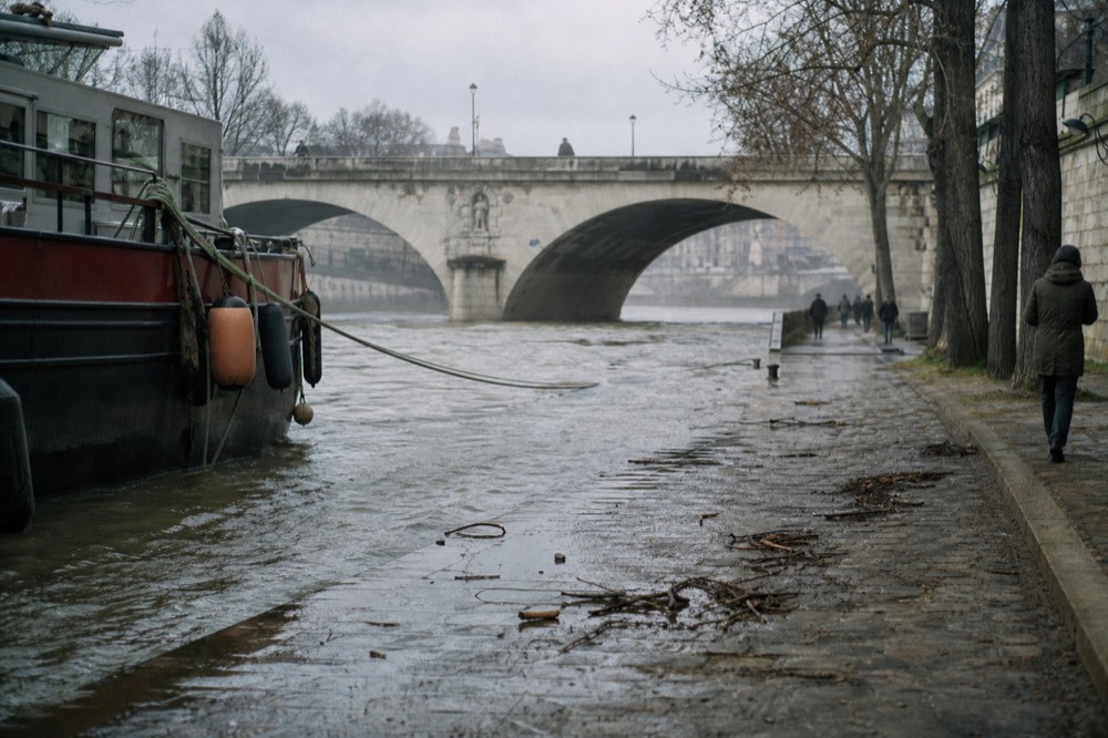 A high Seine river level with water reaching the lower stone quays near a bridge, no text, no logos, no people