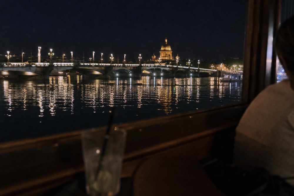 Illuminated bridges and monuments along the Seine at night seen from the water, no text, no logos, no people