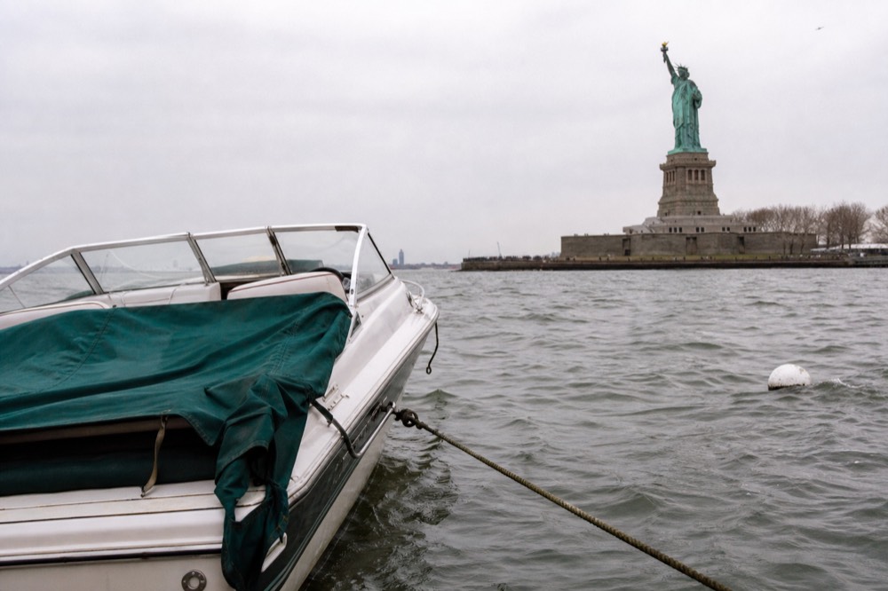 Private small boat moored on the Seine near the Statue of Liberty replica at Port de Javel, no text, no logos, no people